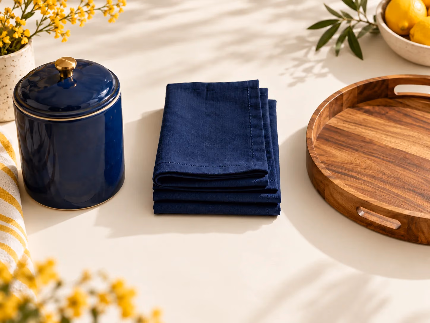 Ceramics, linen, and a wooden tray arranged as separate product groups.